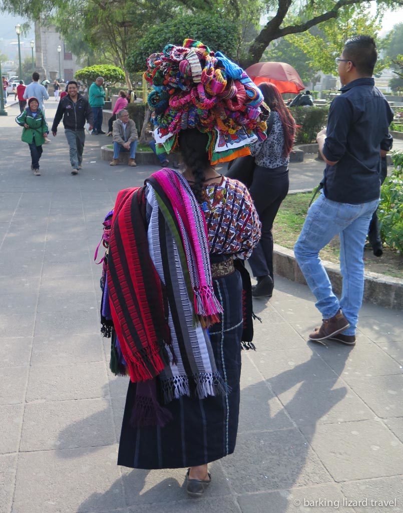 A guatemalan woman in traditional clothes selling textiles in quetzaltenango